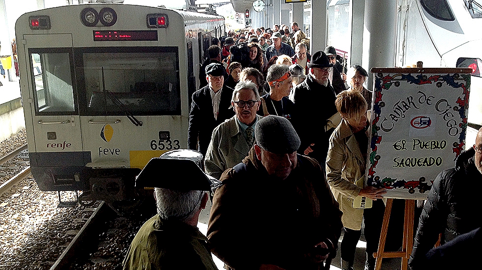 El tren de FEVE Pravia-Gijón, a su llegada a la estación, con la comitiva de SOS Tren Asturias